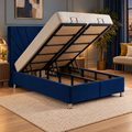 Copeland Ottoman Storage Bed in navy velvet with the lift-up storage open, in a cosy bedroom