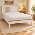 Pebble Wooden Bed Frame in white with oak top rails and a mattress, in a cosy bedroom